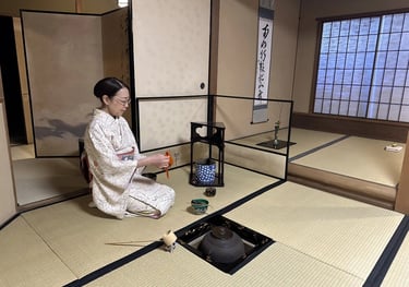 Japanese tea ceremony master sitting in seiza position in a traditional tatami room preparing matcha