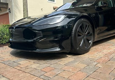 a black tesla tesla parked in front of a house