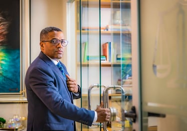 a man in a suit and tie is standing in front of a glass door