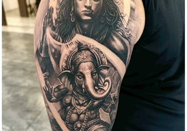 Photo of a religious shiva and ganesha tattoo on the bicep