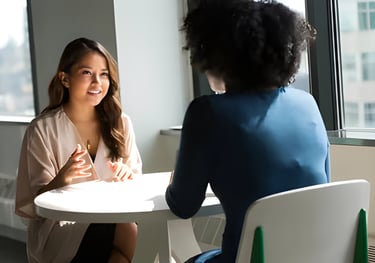 Discussion between two women at Admit 360 Edu Abroad Solutions, emphasizing tailored profile 