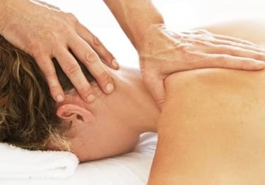 A woman face down getting a neck and shoulder massage.
