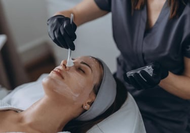 Woman getting a chemical mask brushed onto her face.
