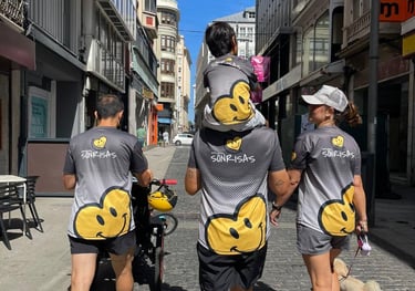 Tres adultos y un menor, miembros de Empujando Sonrisas, pasean por una calle adoquinada