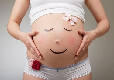 Femme enceinte, mains sur le ventre décoré d'un nœud rose, grossesse sereine et positif hypnose