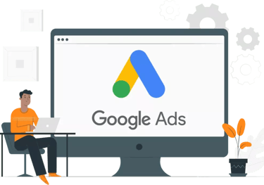 a man sitting at a desk with a laptop looking at google ads logo on the screen
