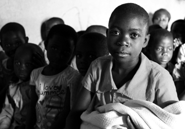 a group of children in a classroom with a blanket