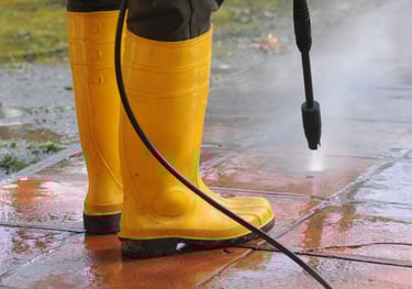 Pressure washing nozzle cleaning an outdoor surface