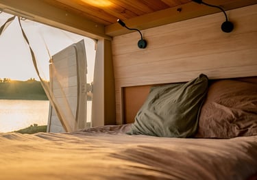 a bed with a view of a lake and a boat
