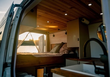 a camper van with a bed and a bed in the back