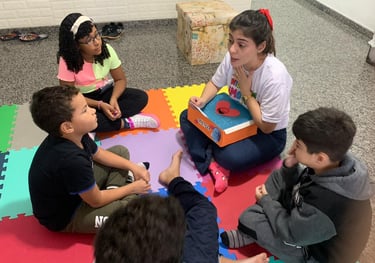 a group of children sitting on a floor with a teacher
