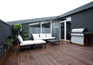 a patio with a couch and a grill