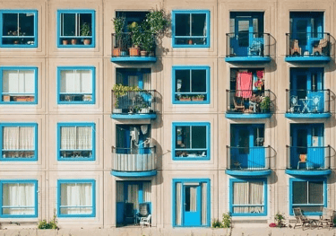 a building with blue windows and a balcony with blue windows