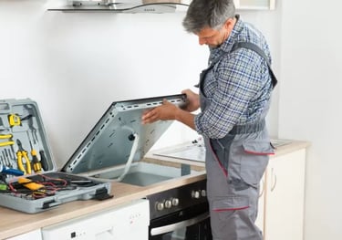 a technician installing a cooktop onto countertop in a kitchen