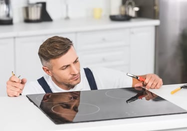 a man holding a plier while looking at a glass cooktop