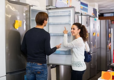 sales person showing a customer new fridge in an appliance store