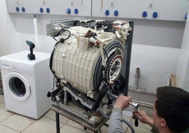 washer outer cover is removed and a technician repairing the shocks of the washer
