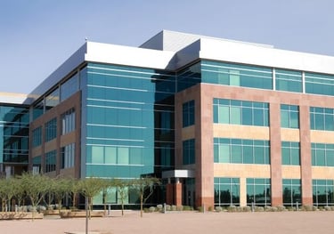 Large, four story office building with a lot of glass windows