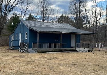 a small blue clubhouse with a metal roof