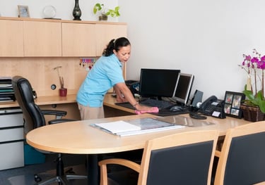 Office cleaner cleaning an office desk