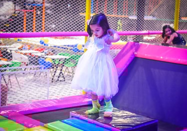 a little girl in a white dress and green socks