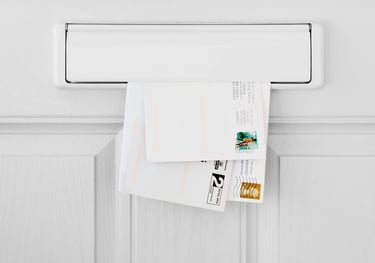 Three mail letters partially visible in an interior door mail slot.