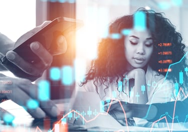 a woman is looking at her phone while she is working on her laptop