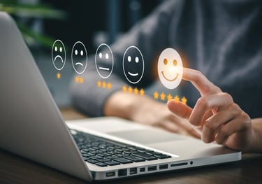 a person pointing at a laptop with smiley faces on it