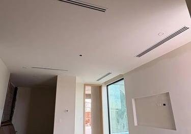 Construcción interior moderna con plafones de panel de yeso blancos y difusores lineales HVAC