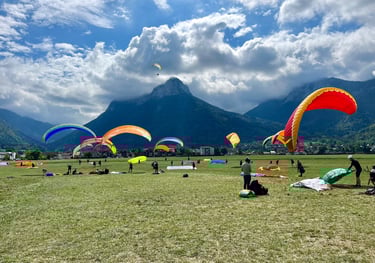 un groupe de personnes s'entraîne à gonfler leur parapente au sol