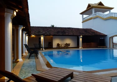 a pool with chairs and a clock tower