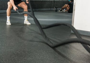 a man is holding a rope rope in a gym