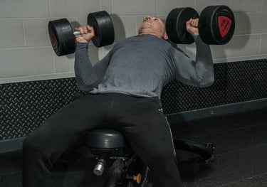 a man is doing a bench press in a gym