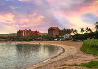 Disney's Aulani Resort towers above the tropical sands of a Hawaiian beachfront.