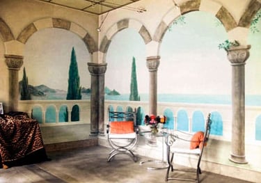Interior of tile showroom with ocean mural, faux sandstone walls, arches and inlay concrete floor.