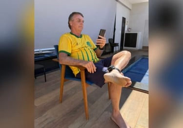 a man sitting in a chair with his feet up and holding a cell phone