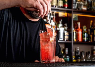 a man is making a drink at a bar