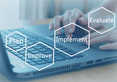 a person using a laptop computer with a plan to improve the performance of a project