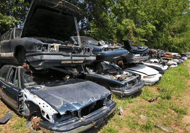 A bunch of scrap cars parked in a lot.