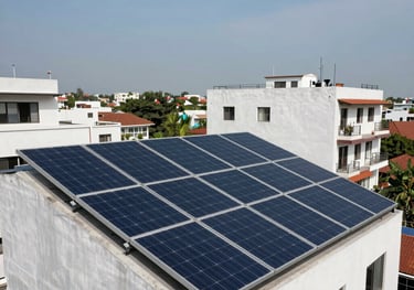 A residential rooftop in a contemporary South Asian urban neighborhood featuring a clean, professional installation of multiple solar panel arrays, under a blue sky.