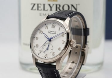 Close-up of a high-end designer watch next to a bottle of Zelyron, symbolizing peak performance and precision, in a soft white and muted blue lighting setting.