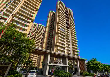 Luxurious high-rise Ivy County residential apartments in Noida under a clear blue sky.