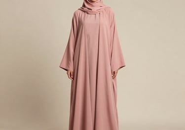 Full-length photography of a dusty rose abaya and matching inner dress set against a minimalist beige wall. The model is posed naturally to show the flow of the garment. Clean composition in a Middle Eastern / Gulf context.
