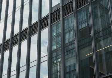 A photograph focusing on the modern architectural detail of a glass building façade, capturing the professional and trustworthy mood of a financial center.