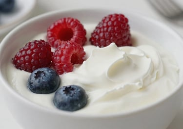 Close-up of a premium yogurt bowl with fresh berries, clean and bright lighting, showcasing dairy freshness in a Latin American / Spanish breakfast setting.
