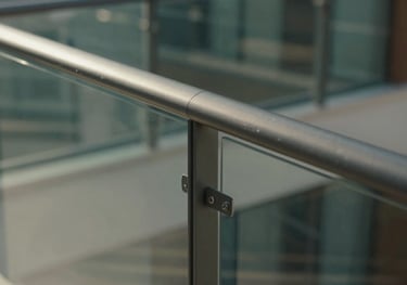 Detailed view of a sliding glass balcony system in a luxury apartment, showing the smooth rail mechanism and transparent panels.