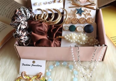 A collection of fashion accessories including gold hoop earrings, pearl hair clips, silk scrunchies, and a smiley face