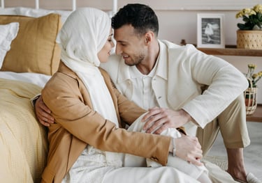 a man and woman sitting on a bed