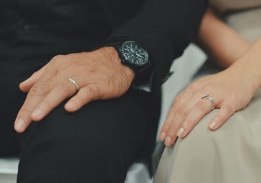 a man and woman holding hands and wearing rings