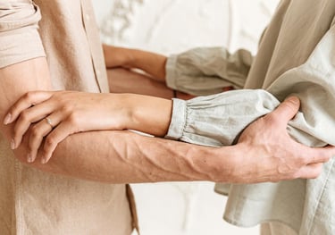 a man and woman holding hands and looking at each other